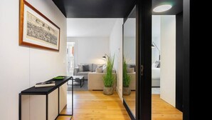 Ein modernes Wohnzimmer mit einer Couch, einem Couchtisch und Topfpflanzen.