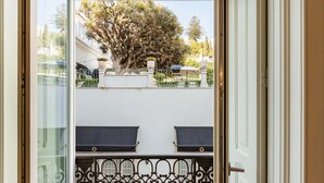 A balcony with a view of a tree and a building in the background. - Liberdade Deluxe Apartment | AC | S-Pool | Parking (Lisboa)