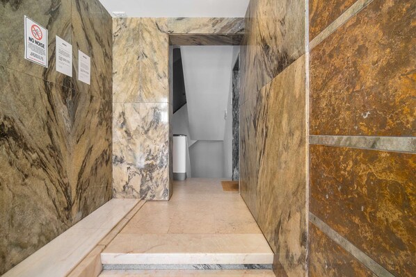 Una escalera de mármol que conduce a una habitación con una puerta blanca.
