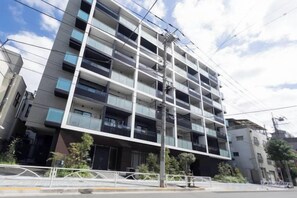 A multi-story building with balconies, a pedestrian walkway, and a street in front. - Park Axis Honjo Azumabashi South Residence (Tokyo)