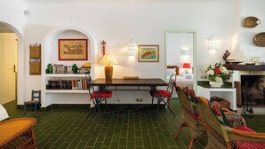 Un comedor con una mesa, sillas y una estantería.