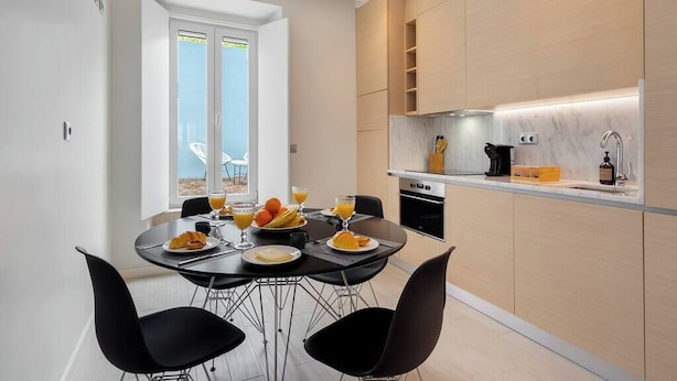 Eine moderne Küche mit Essbereich, ausgestattet mit einem Frühstücksangebot, darunter Croissants und Orangensaft.