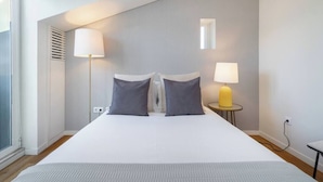 A modern hotel room with a large bed, two bedside lamps, and a small table. - Alcântara Premium 2-bed | Wi-Fi | Lx Factory (Lisboa)