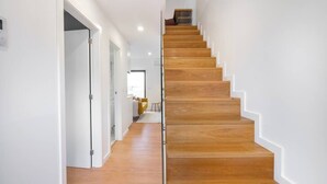 Eine moderne Treppe mit Holzstufen und weißen Wänden.
