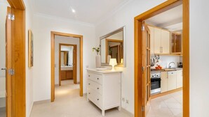 A modern kitchen with white cabinets, a stove, and a sink. - Family Holidays w/ S-Pool | AC | Elevator | Garage (Quarteira)