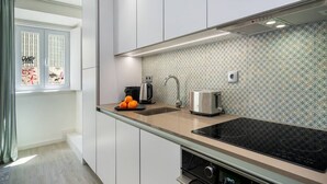 A modern kitchen with a built-in stove, a sink, and a toaster. - Lisbon Prime Aparts - Anjos (Lisboa)