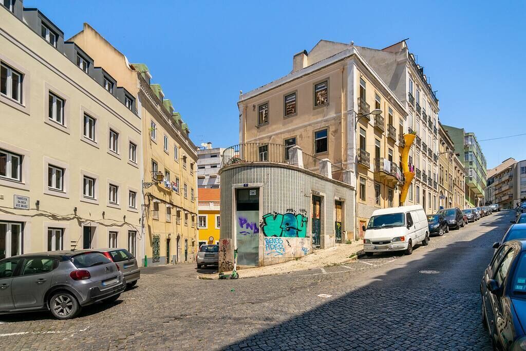Une rue pavée bordée d’immeubles à plusieurs étages, dont certains sont dotés de balcons et d’enseignes.