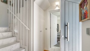Een trap die leidt naar een kamer met een witte deur en een schilderij aan de muur.