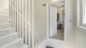 A staircase with white railings leading to a room with a bed and a window. - Lisbon Prime Aparts - Anjos (Lisboa)