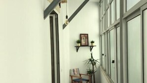 A narrow corridor with a wooden bench, a table, and a hanging light fixture. - Family Apartment with Balcony in Graça (Lisboa)