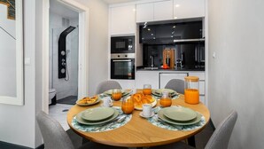 Een moderne keuken met witte kastjes, een zwart aanrecht en een ingebouwde oven.