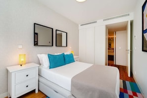 Une chambre à coucher avec un lit, des tables de chevet, une armoire et un miroir.