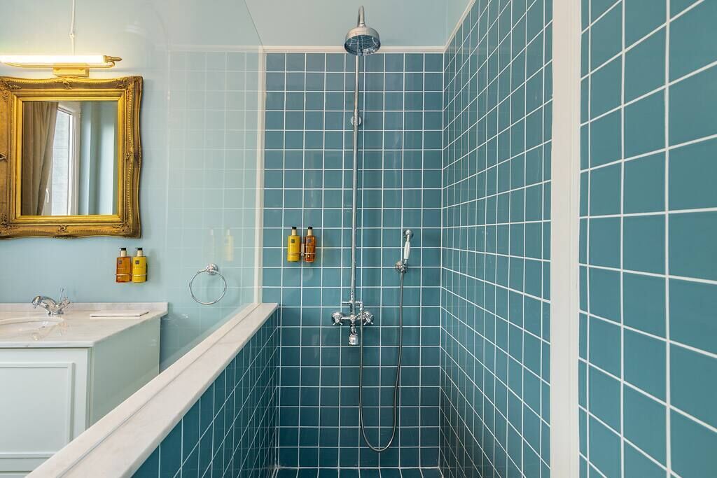 A bathroom with a shower, a sink, and a mirror.