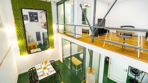 Ein modernes Interieur mit Essbereich, Küche und einer oberen Ebene mit Balkon.