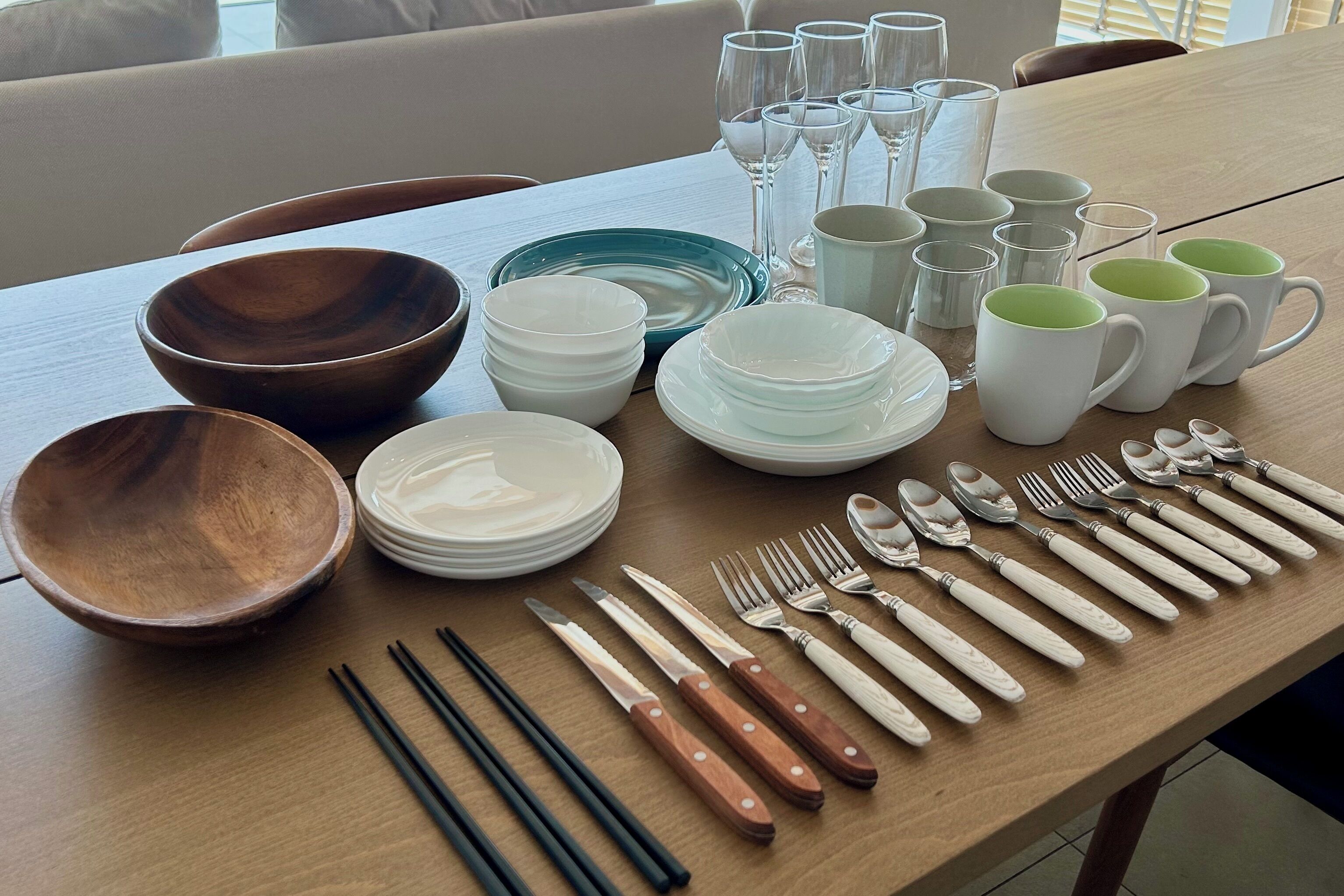 A dining table set with various bowls, plates, cups, and cutlery.