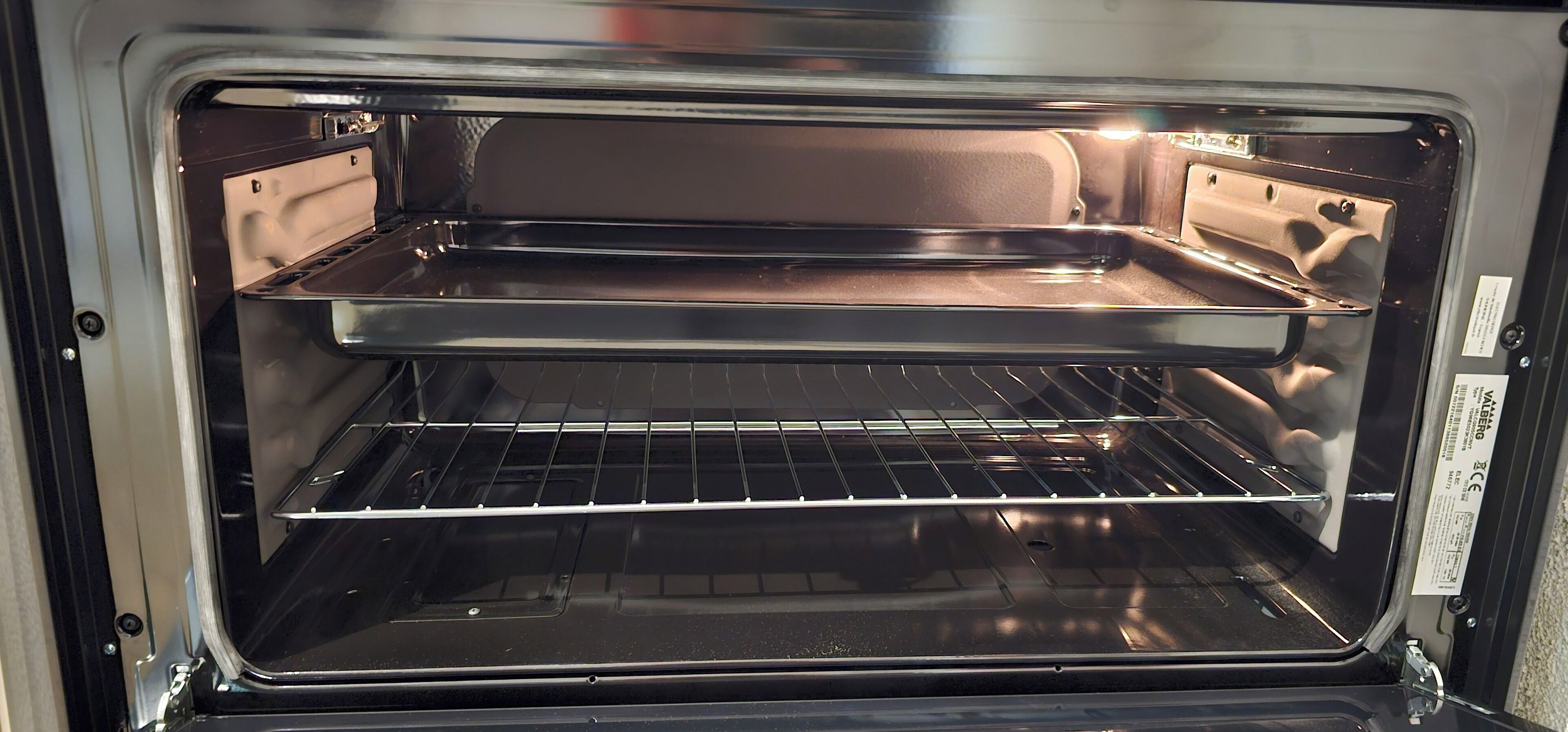 Horno doble vacío con una rejilla metálica y un panel de control a la derecha.