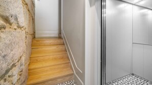 Un ascensor moderno con detalles metálicos y un suelo de diseño geométrico.