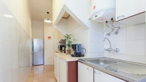 Een moderne keuken met witte kasten, een roestvrijstalen spoelbak en een inbouwoven.