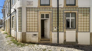 Un edificio con fachada de tejas, una puerta y una ventana.