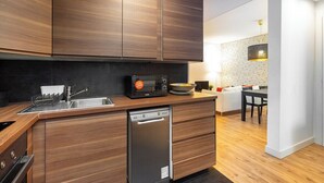 A modern kitchen with wooden cabinets, a built-in dishwasher, and a microwave.