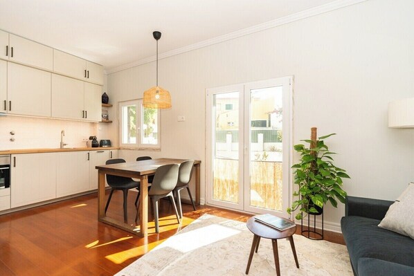 A modern apartment with a kitchen, dining area, and living room.