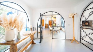 A modern interior with a wooden bench, a standing lamp, and a dining area with a glass partition. - Family Paradise: Exquisite Retreat for Holidays (São Miguel do Rio Torto)