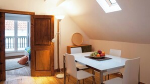A dining area with a table set for four, a lamp, and a fruit bowl.