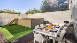 An outdoor patio with a dining table set for four, surrounded by white chairs. - Suburban Serenity: Family Home with Pool (Algés)
