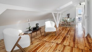 Camera da letto in stile loft moderna con soffitto a sbalzo, pavimento in legno e zona pranzo con tavolo e sedie.