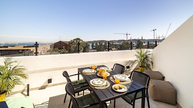 Una terrazza sul tetto con un tavolo apparecchiato per mangiare, con vista sulla città.