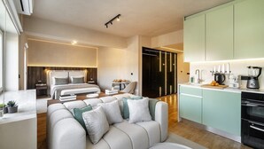Ett modernt hotellrum med ett vardagsrum, ett separat sovrum och ett litet kök.