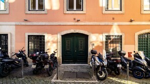 A building with a green door and windows, parked motorcycles in front.