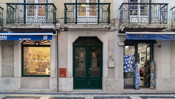 A building with a green door, a shop with a blue awning, and a patterned tile floor. - Lisbon Living Redefined: Exclusive Downtown Spot (Lisboa)