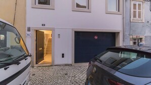 En byggnad med en mörkblå garageport, ett tydligt synligt nummer ’68’ och en skylt med texten ”Parkering förbjuden”.