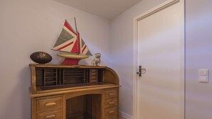 A wooden desk with drawers, a small ship model, and a football. - Polo Room - Clean & Safe (Lisboa)