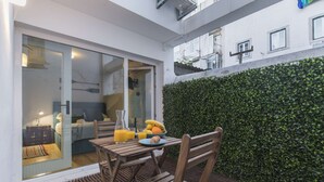 Une table en bois avec des aliments pour le petit-déjeuner, un verre de jus d’orange et un bol de fruits.