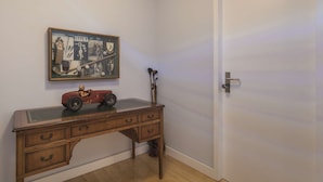 Ein Holztisch mit Schubladen, ein gerahmtes Bild mit Golf-Erinnerungsstücken und ein Spielzeugauto.