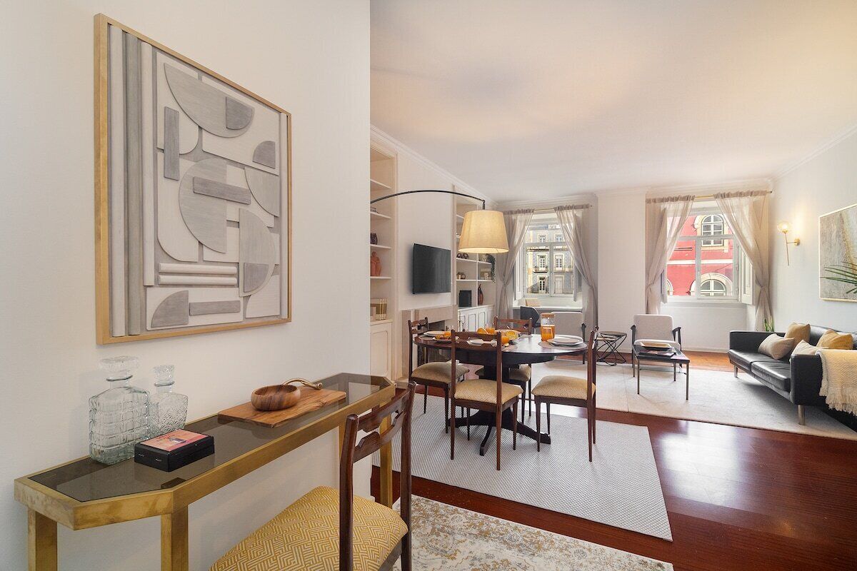 Un salon moderne avec un coin repas, comprenant une grande peinture abstraite, une table à manger en bois et des sièges confortables.