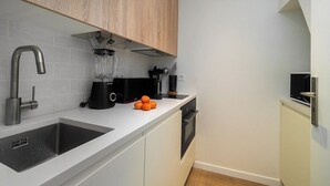 A modern kitchen with two sinks, a blender, and a coffee maker.