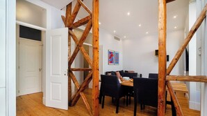 Ein Essbereich mit einer Holztreppe, einem Esstisch mit Stühlen und einer weißen Tür.