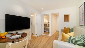 A modern apartment with a dining area, a living room, and a bedroom. - Modern Flat in Bica’s Historic Charm (Lisbon)