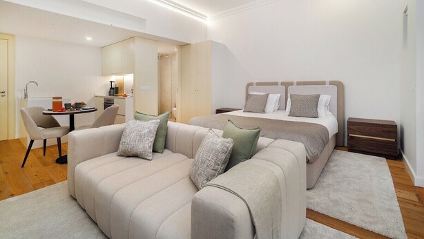 A modern hotel room with a sofa, a bed, a small table, and a chair. - Modern Studio in Santa Catarina (Porto)