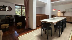 Ein moderner Essbereich mit einer zentralen Kochinsel, Holzmöbeln und Pendelleuchten.