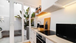 A modern kitchen with a built-in oven, a Samsung refrigerator, and a wooden countertop.