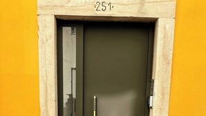 A dark-colored door with a brass handle and a small sign above it. - Lisbon Charm: Walk to Graça Viewpoints (Lisbon)