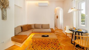Een moderne woonkamer met een bank, een salontafel en een eethoek met een tafel en stoelen.