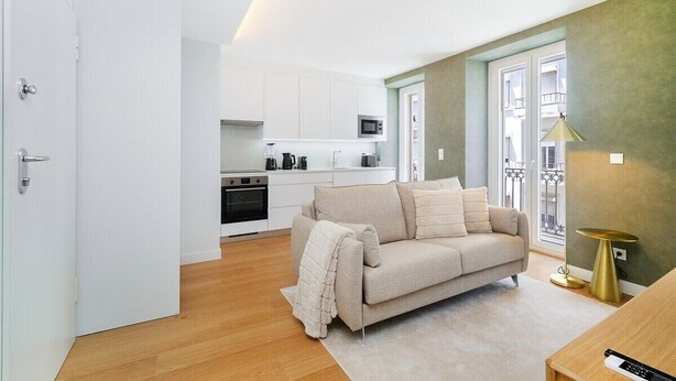 A modern apartment with a kitchen, a living area with a sofa, and a dining table. - Light-Filled Studio with a True Neighborhood Feel (Lisbon)