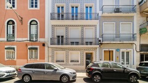 Une rangée d’immeubles à étages, dotés de balcons, certains avec des garde-corps en métal et d’autres avec des motifs en carreaux.