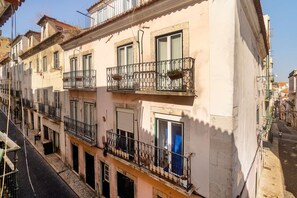 Une rangée de bâtiments traditionnels dotés de balcons, de rues étroites et d’un pavé de pierres.