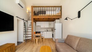 A compact living space with a loft bedroom, kitchenette, and a dining area. - Sunny Studio Stay in Central Oeiras (Oeiras)